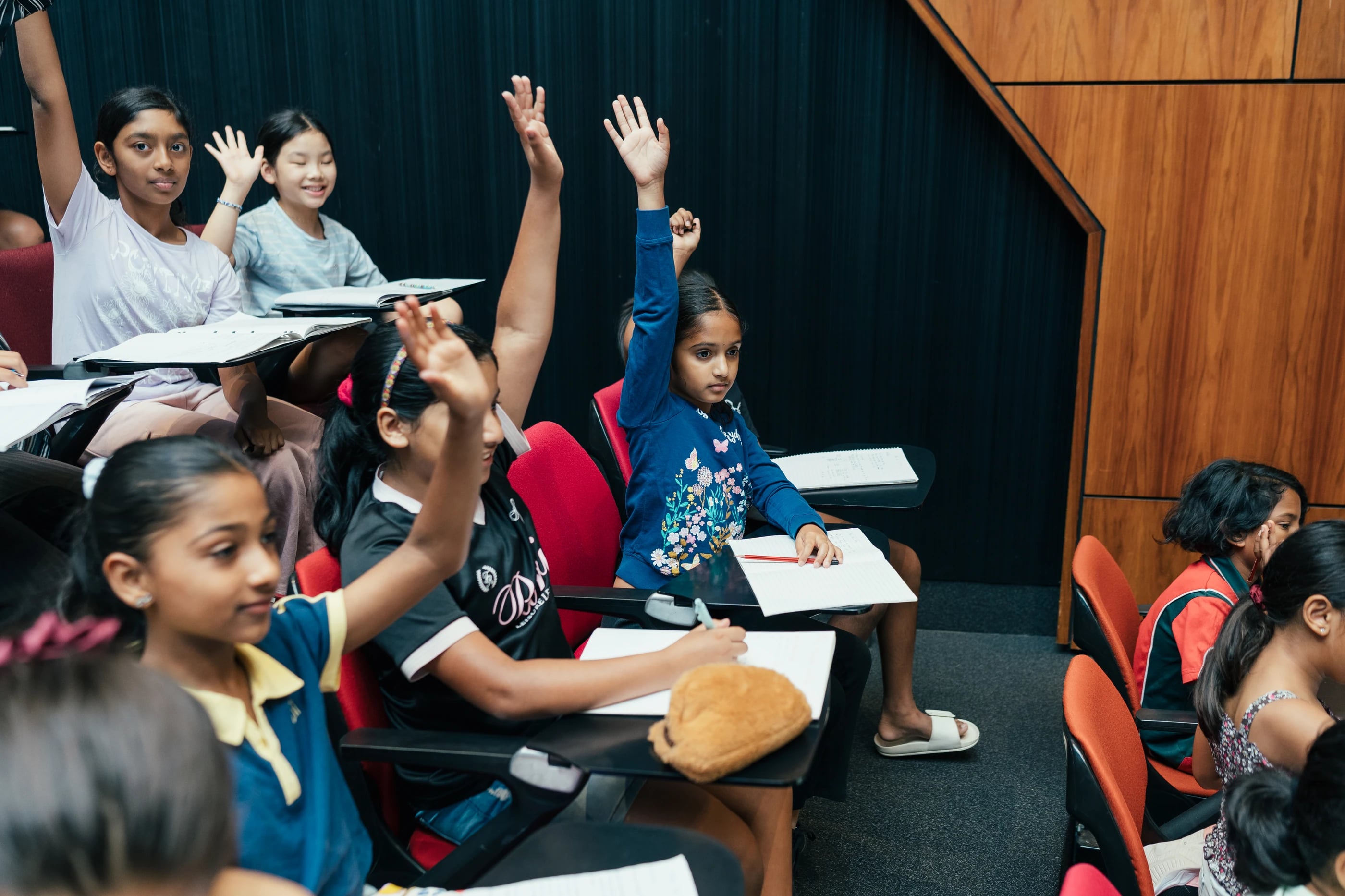 Students raising their hands to answer a question