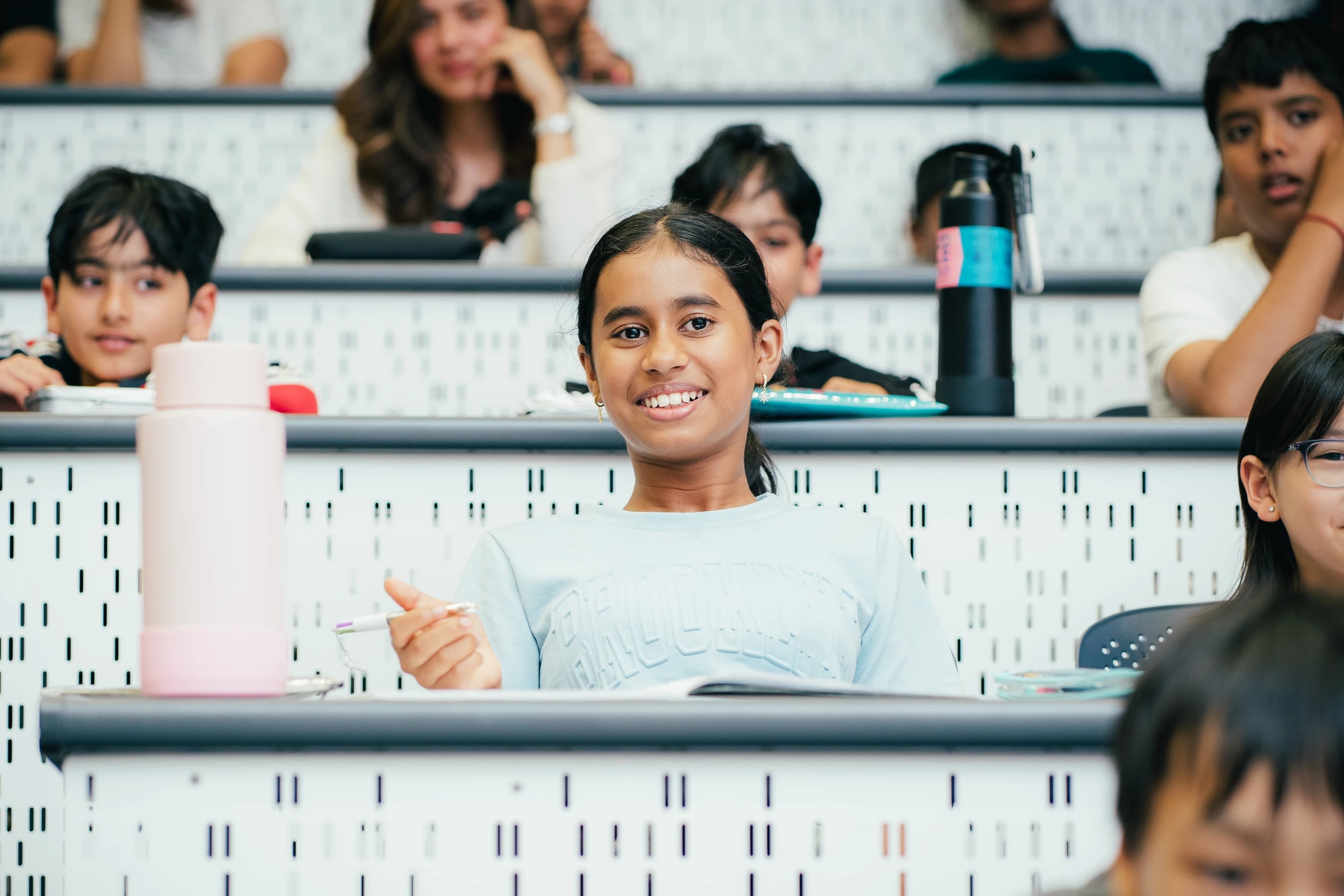 A student smiling at her desk