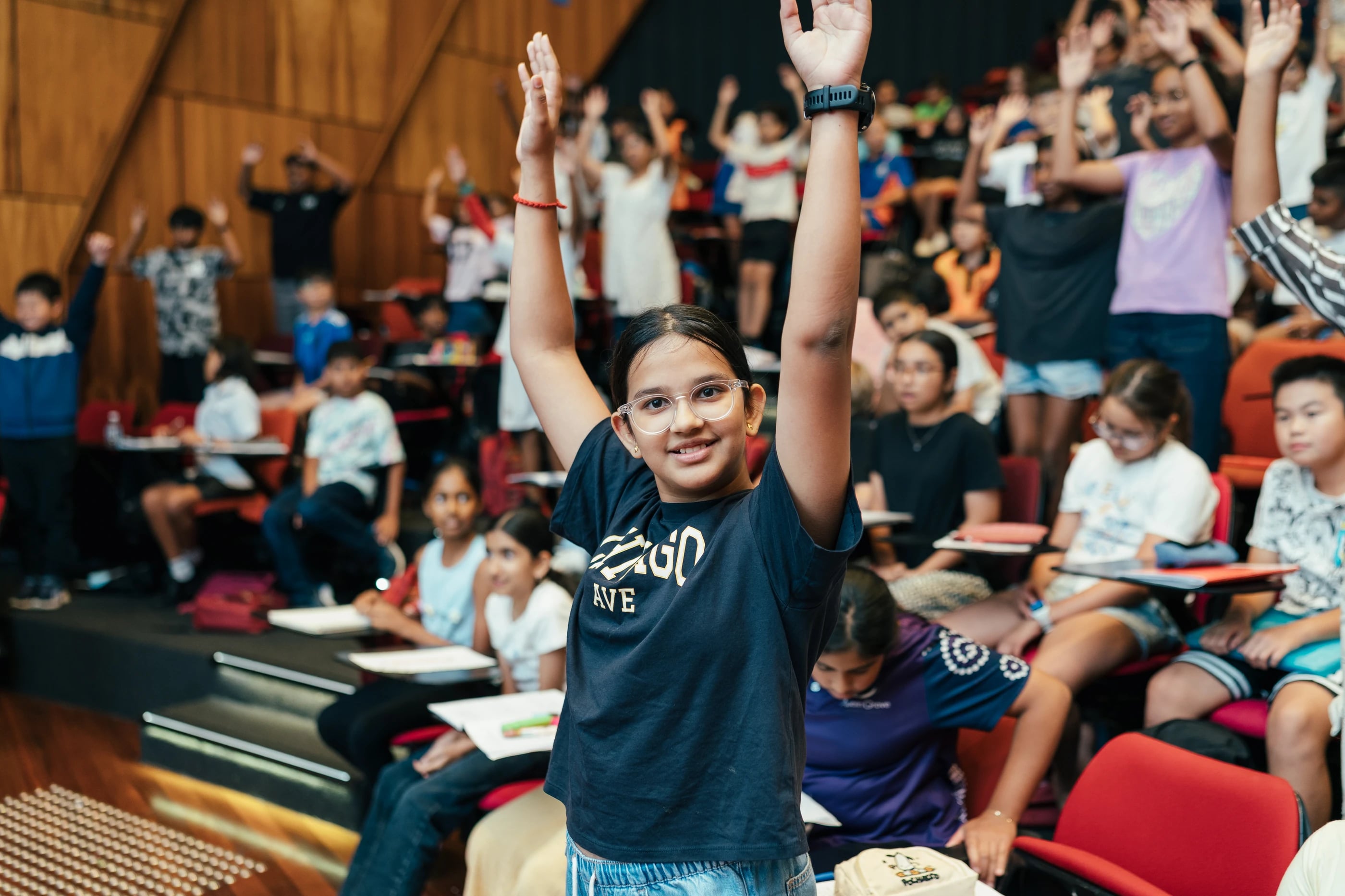 Students raising their hands during an interactive Loyola lesson