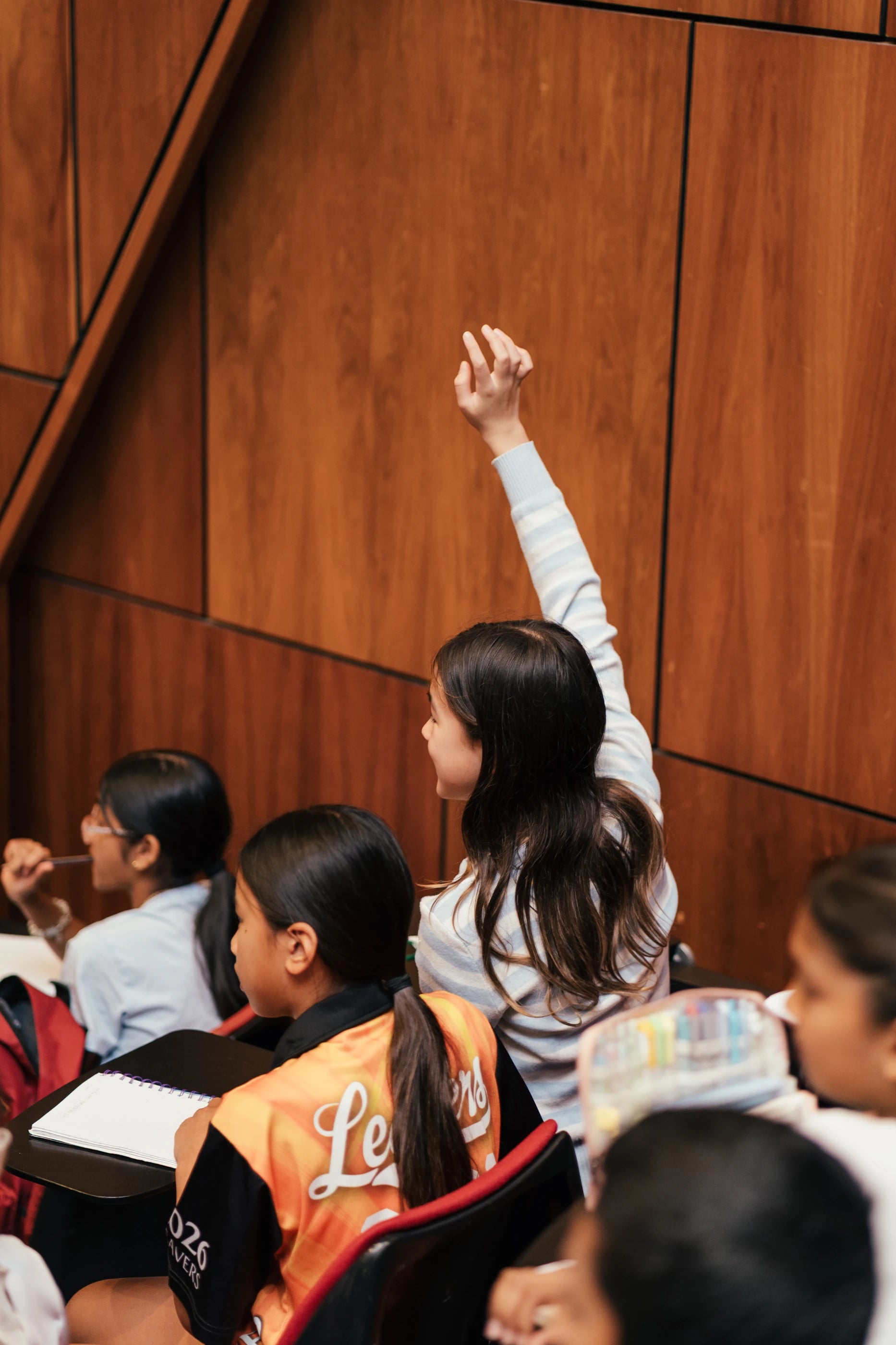 A student raising her hand to contribute
